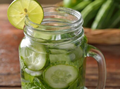 Cucumber water in mason jar with lime slice. Cucumber water in mason jar with lime slice.